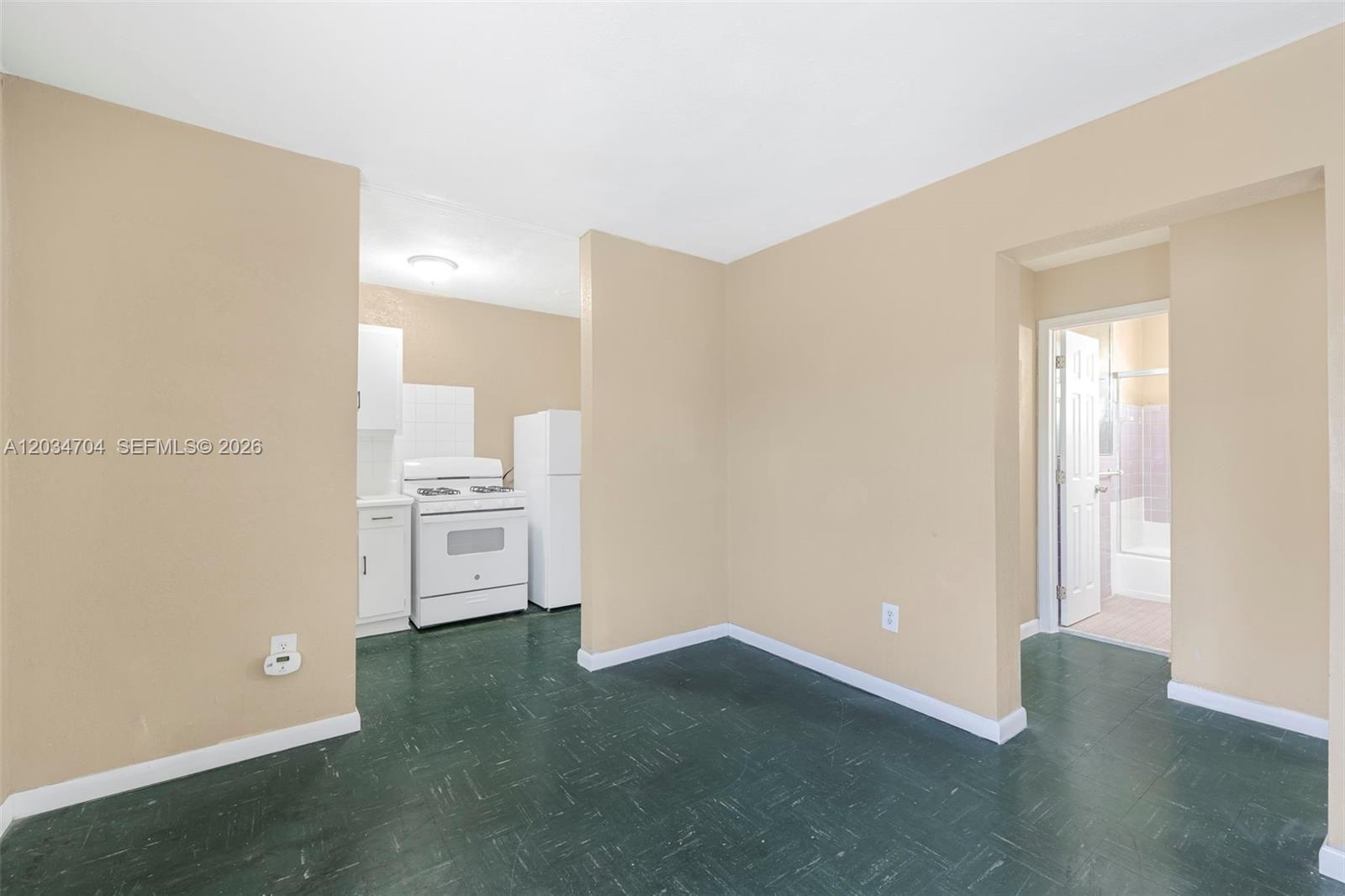 A kitchen area with white appliances and green flooring is visible next to a bathroom — 126 SW 18th Ave # 11, Miami FL 33135, MIAMI, FL