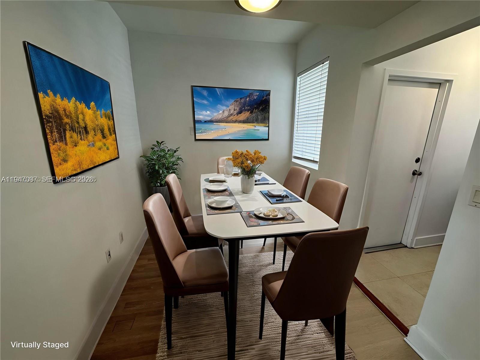 A dining room features a white table with six chairs, two wall paintings, and wood flooring — 1000 Meridian Ave # 17, Miami Beach FL 33139, MIAMI BEACH, FL