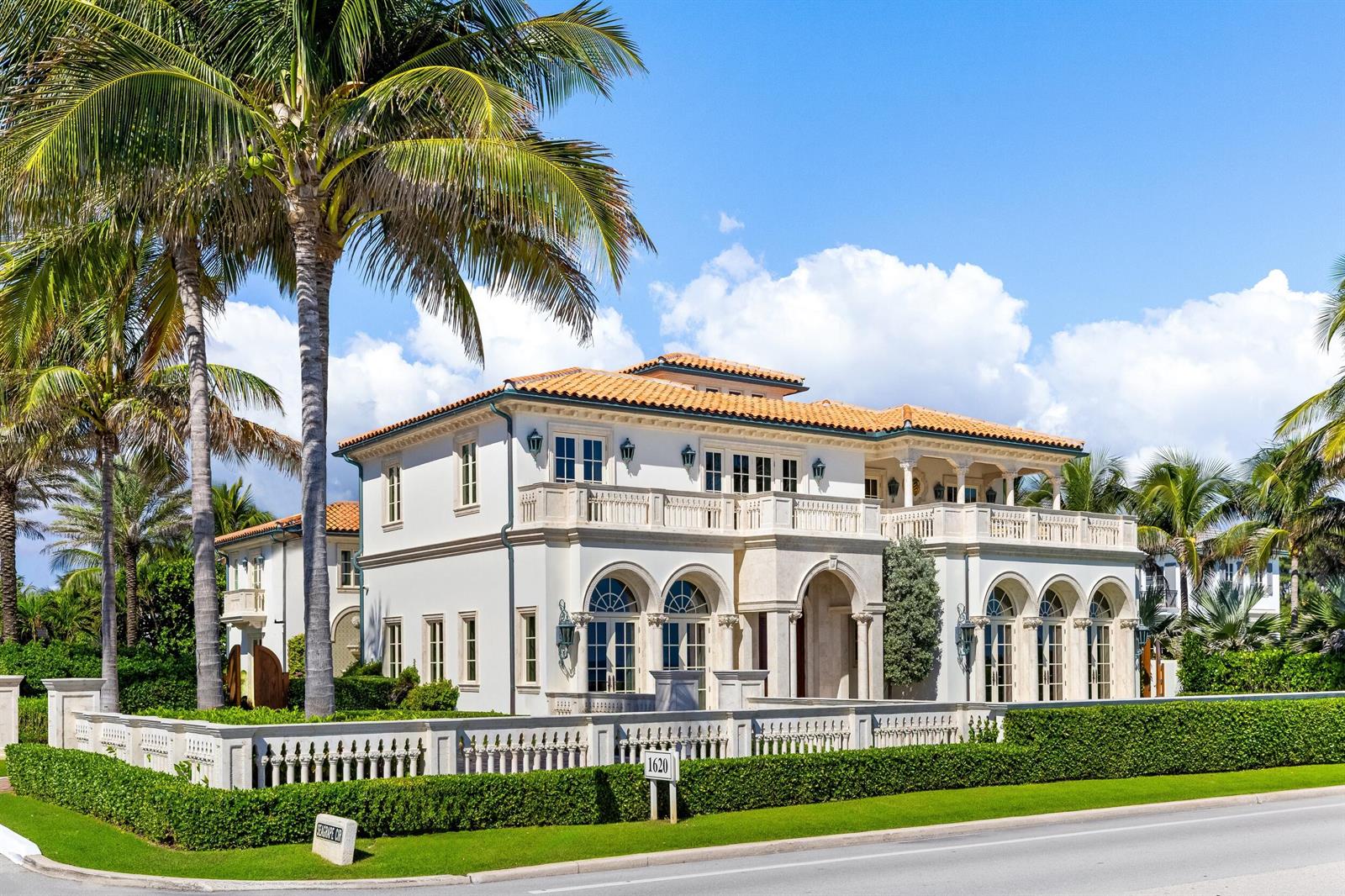 A large Mediterranean-style mansion with a tile roof, arched windows, and a manicured hedge fence — 1620 S Ocean Boulevard, Palm Beach FL 33480, PALM BEACH, FL