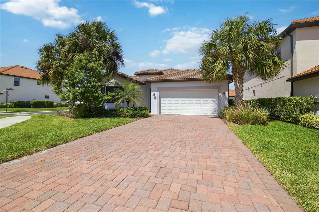 A single-story house with a paved driveway, a two-car garage, and palm trees — 19345 CRUISE DRIVE, VENICE, FL