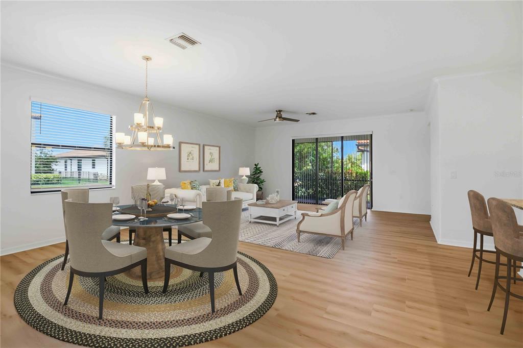 An open-concept living and dining area features light wood flooring, a chandelier, and sliding doors — 19345 CRUISE DRIVE, VENICE, FL