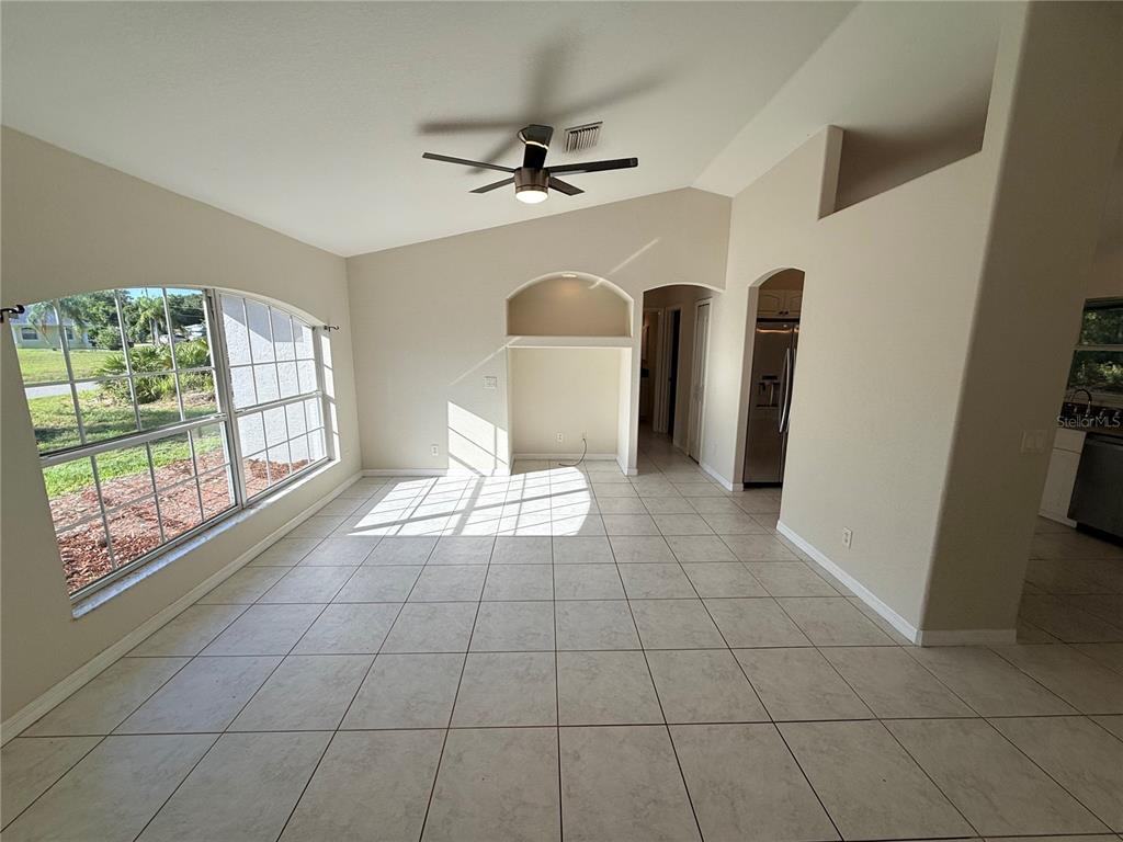 A bright room with light tile flooring, a ceiling fan, and a built-in arched niche — 4185 AMARI ROAD, NORTH PORT, FL