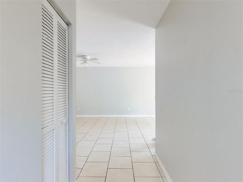 A view through a doorway shows a room with light-colored tile flooring and a ceiling fan — 1307 BOND STREET, EDGEWATER, FL