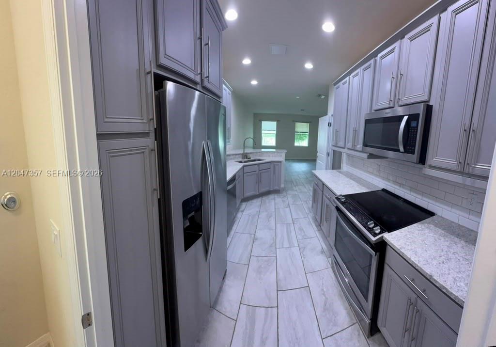 A galley-style kitchen features gray cabinets, stainless steel appliances, and light-colored countertops — 4022 Long Leaf Ln # 4022, Hollywood FL 33021, HOLLYWOOD, FL