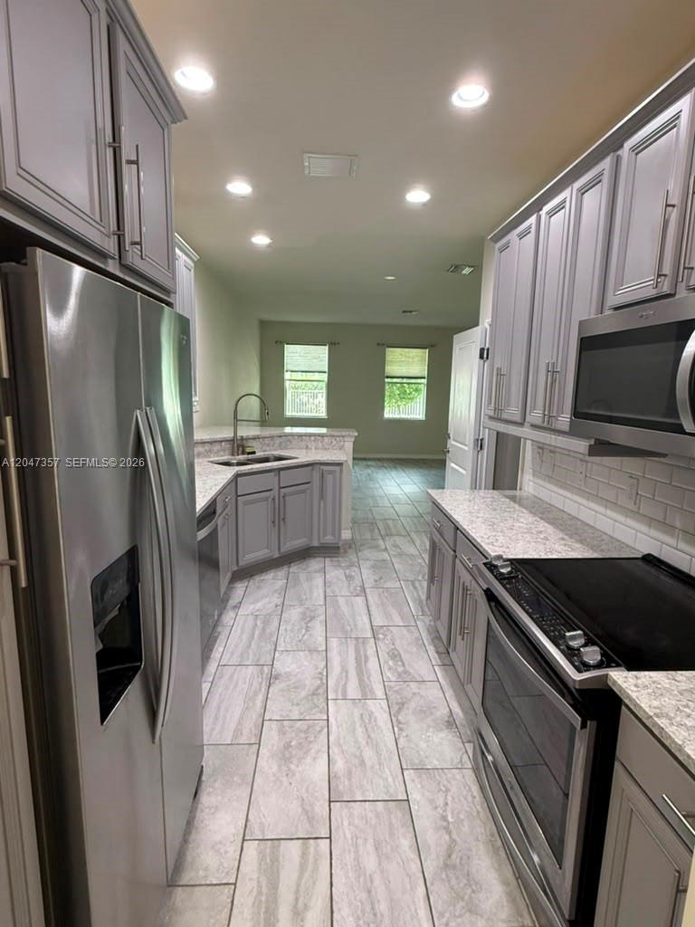 A kitchen with gray cabinets, stainless steel appliances, and light-colored tile flooring — 4022 Long Leaf Ln # 4022, Hollywood FL 33021, HOLLYWOOD, FL