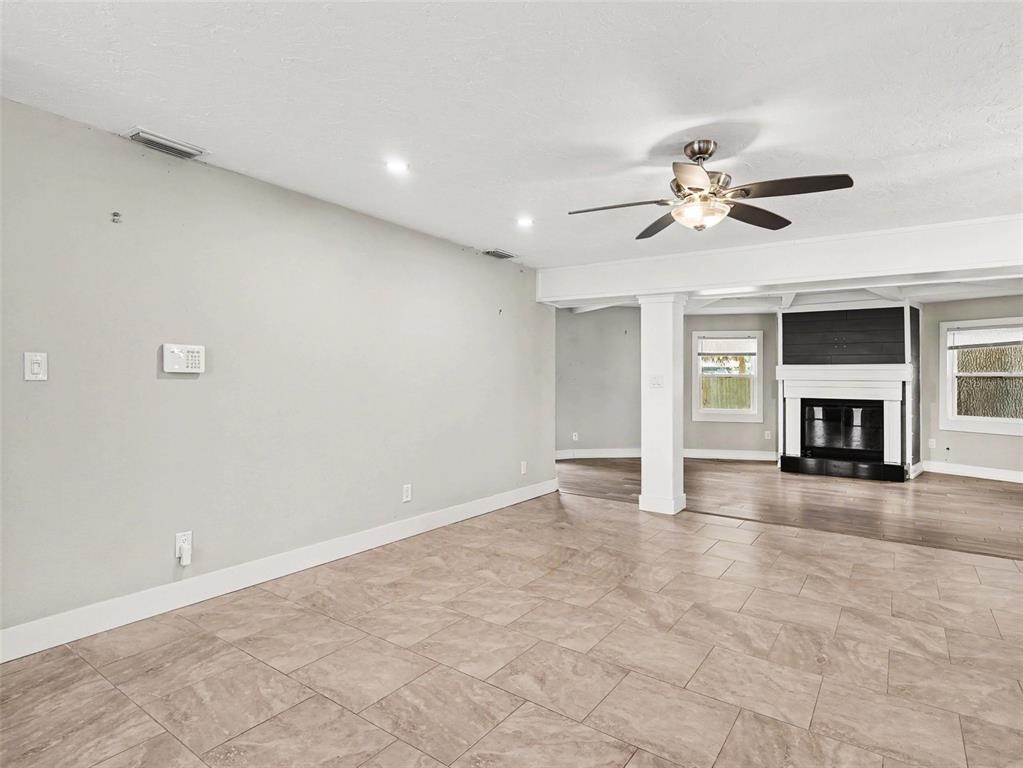 A living room features light-colored tile flooring, a ceiling fan, and a fireplace — 2746 HIBISCUS STREET, SARASOTA, FL