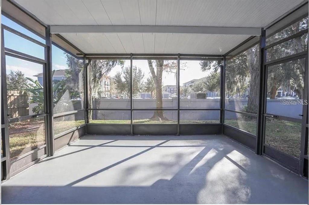 A screened-in porch with a concrete floor and views of a yard and trees — 12834 WOODBURY GLEN DRIVE, ORLANDO, FL