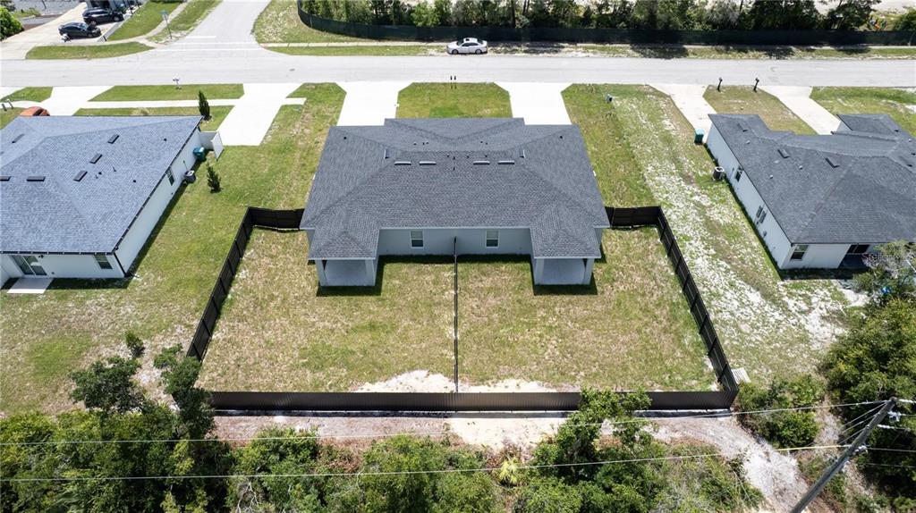 An aerial view shows the back of a duplex with fenced-in yards and patios — 2232 FERNWOOD STREET, DELTONA, FL