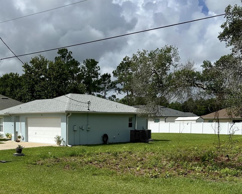 A light blue house with a white garage door and a white vinyl privacy fence — 10 ZIEGFELD PLACE, PALM COAST, FL