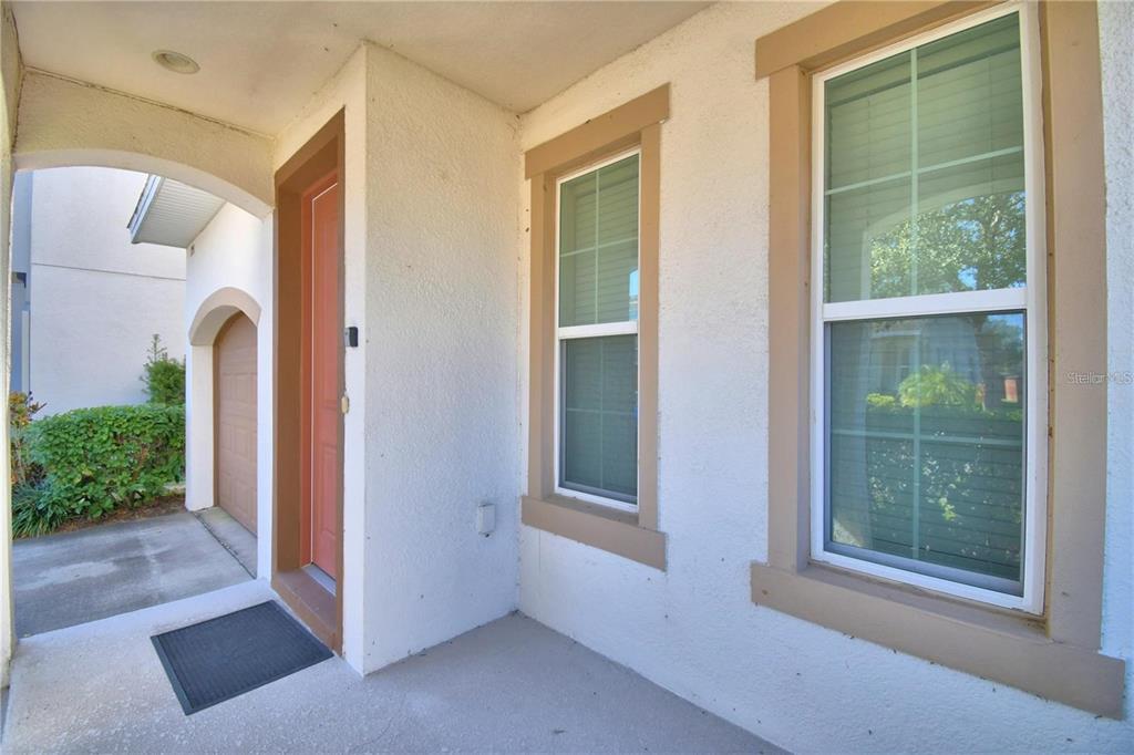 A view of a home entrance with a red door, two windows, and a garage — 193 ABERDEEN STREET, DAVENPORT, FL