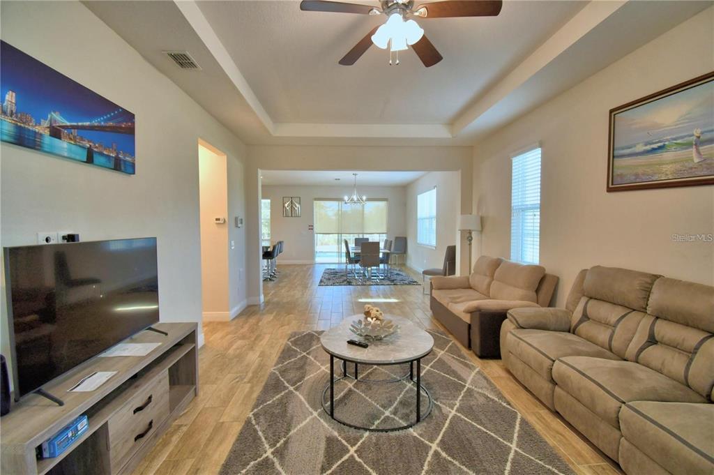 A living room with tile flooring, a tray ceiling, and an open floor plan — 193 ABERDEEN STREET, DAVENPORT, FL
