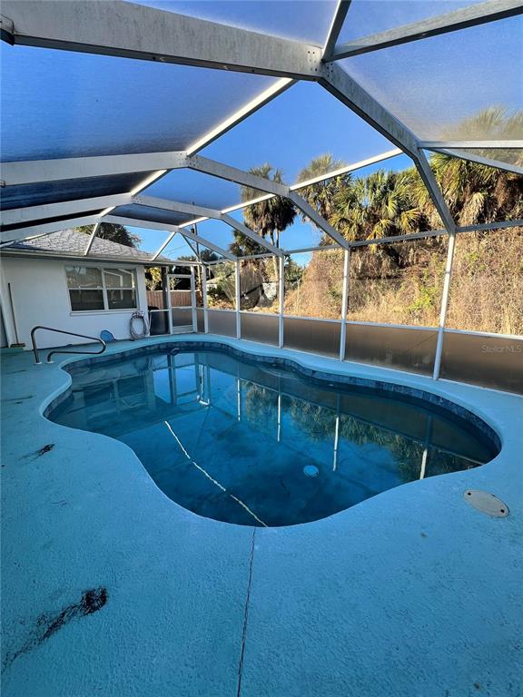 A swimming pool is enclosed by a screened lanai with a painted concrete deck — 4009 ATWATER DRIVE, NORTH PORT, FL