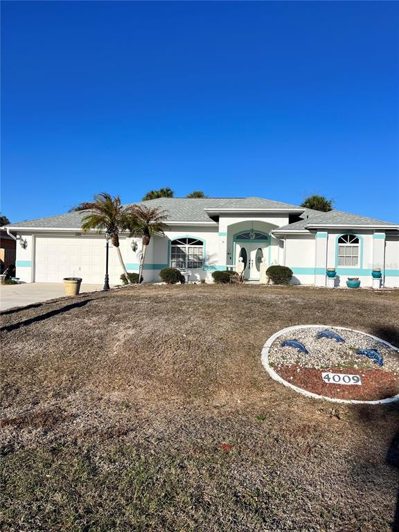 A single-story house with a white exterior, turquoise trim, and a circular address marker — 4009 ATWATER DRIVE, NORTH PORT, FL