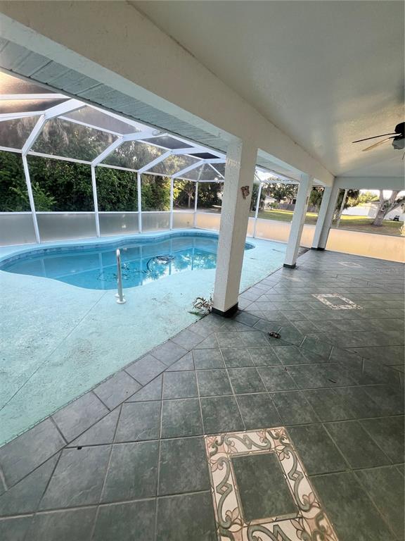 A covered patio with tiled flooring overlooks a screened-in swimming pool — 4009 ATWATER DRIVE, NORTH PORT, FL