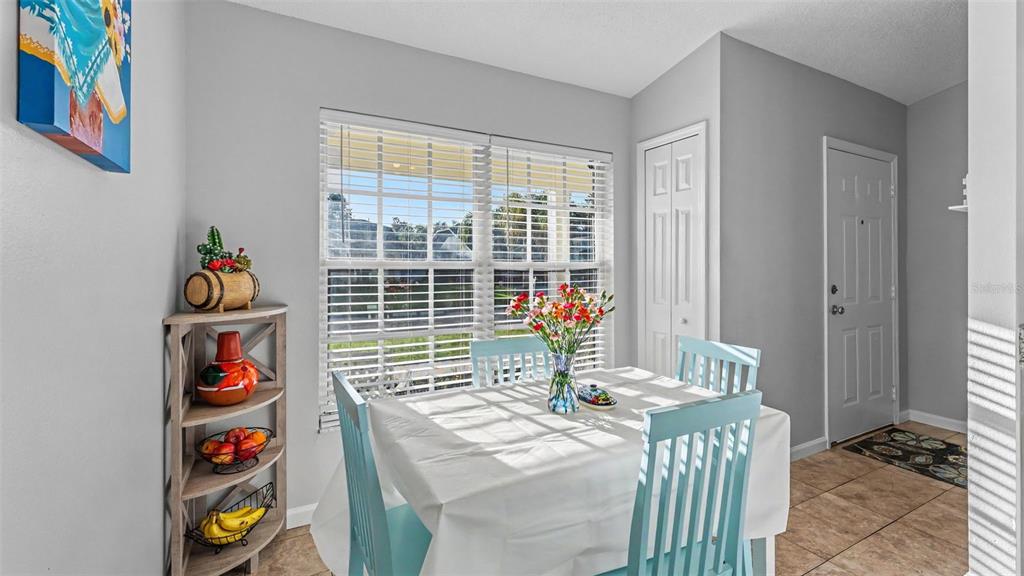 A dining area features a white-clothed table, light blue chairs, and a corner shelving unit — 5563 STARLING LOOP, LAKELAND, FL