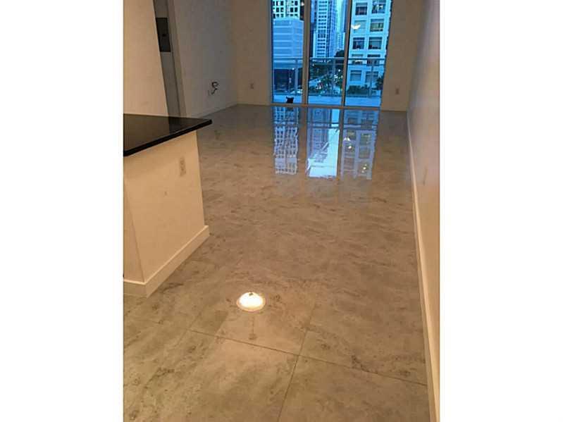A room with large, polished light-gray floor tiles and a view of city buildings outside — 951 Brickell Avenue # 701, Miami FL 33131, MIAMI, FL