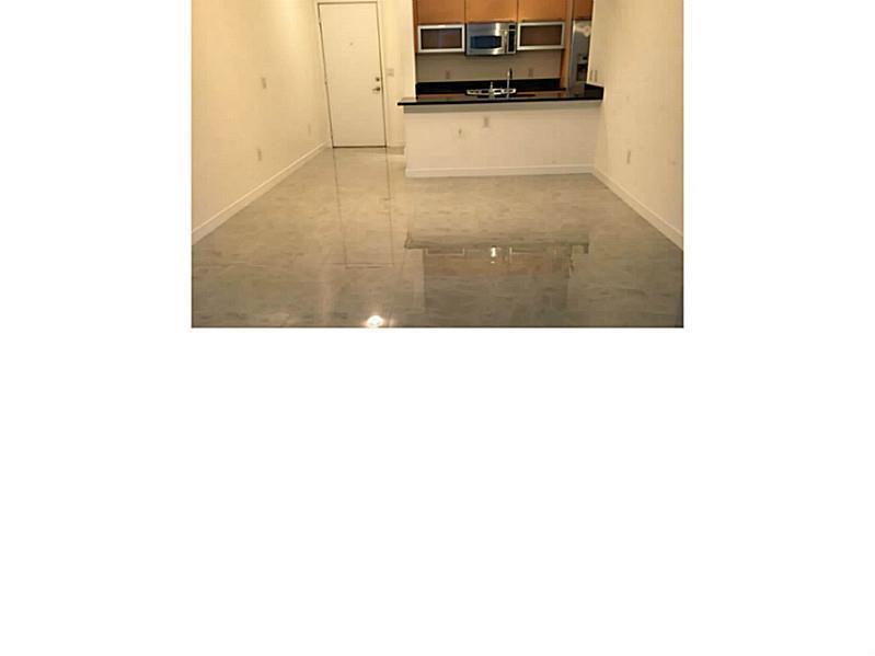 An open-concept living area features light-colored tile flooring and a kitchen with dark countertops — 951 Brickell Avenue # 701, Miami FL 33131, MIAMI, FL