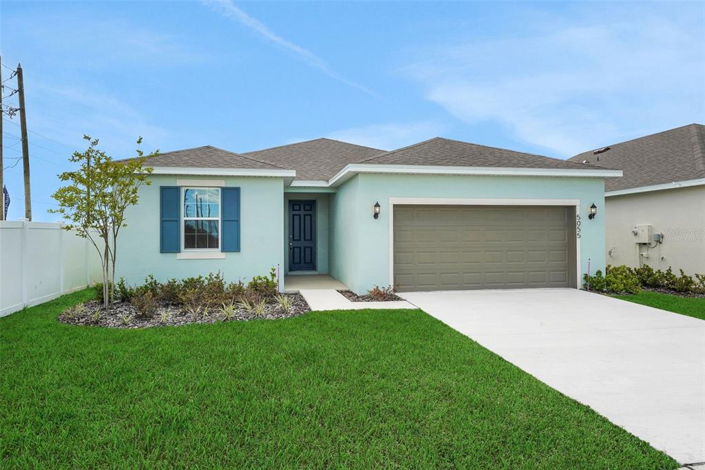A light green single-story house with a two-car garage and a blue-shuttered window — 5055 ABIGAIL DRIVE, LAKE WALES, FL