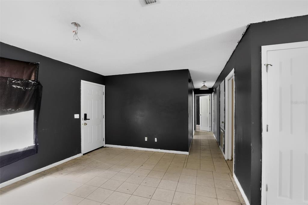 An interior room features black walls, white trim, a white door, and light-colored tile flooring — 5179 MARCUS DRIVE, GREENWOOD, FL