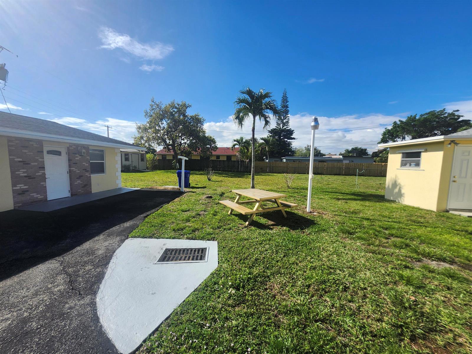A backyard features a picnic table, a palm tree, and two small buildings on grass — 511 N 60th Way, Hollywood FL 33024, HOLLYWOOD, FL