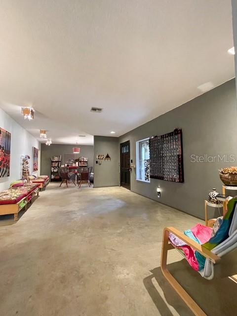 A spacious room with concrete floors, recessed lighting, and a dark accent wall — 306 CASLER AVENUE, CLEARWATER, FL