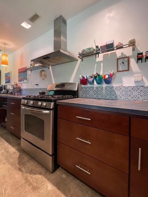 A kitchen features dark wood cabinets, a stainless steel range, and a metal vent hood — 306 CASLER AVENUE, CLEARWATER, FL