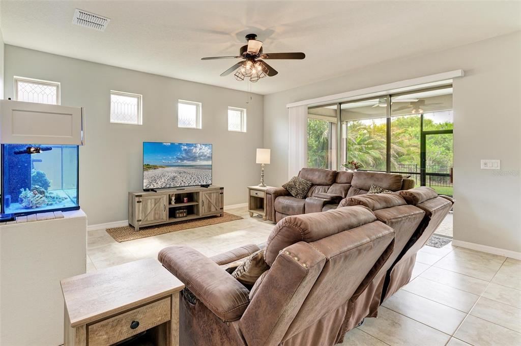 A living room features a large sectional sofa, a television on a console, and an aquarium — 10708 52ND COURT E, PARRISH, FL