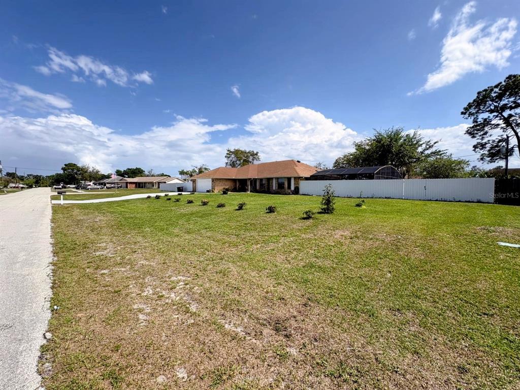 A single-story house with a brown roof sits behind a large grassy yard — 3958 CARRICK BEND DRIVE,, KISSIMMEE,, FL