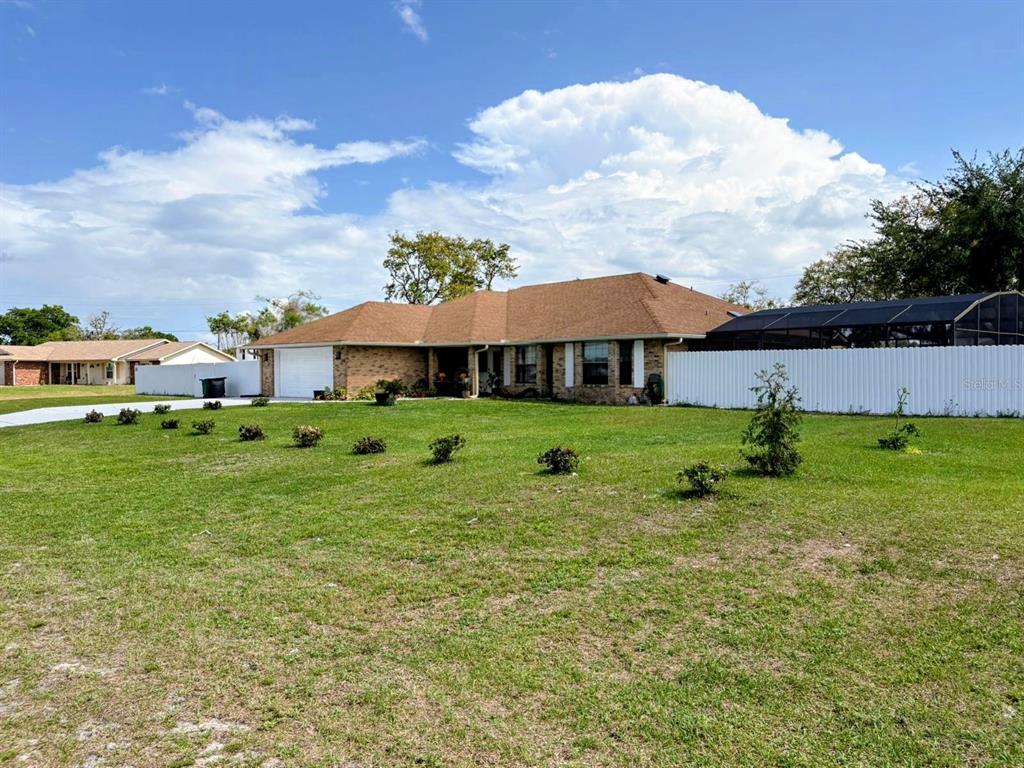 A single-story brick house with a brown roof and a white privacy fence — 3958 CARRICK BEND DRIVE,, KISSIMMEE,, FL