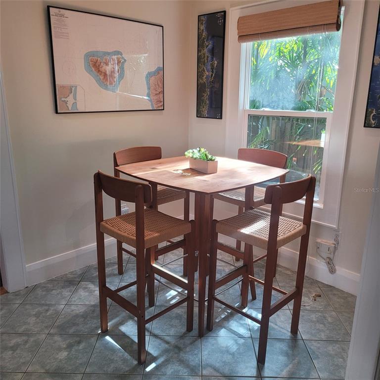 A dining area features a high-top wooden table with four woven-seat stools on tiled floors — 2916 W BAY COURT AVENUE, TAMPA, FL