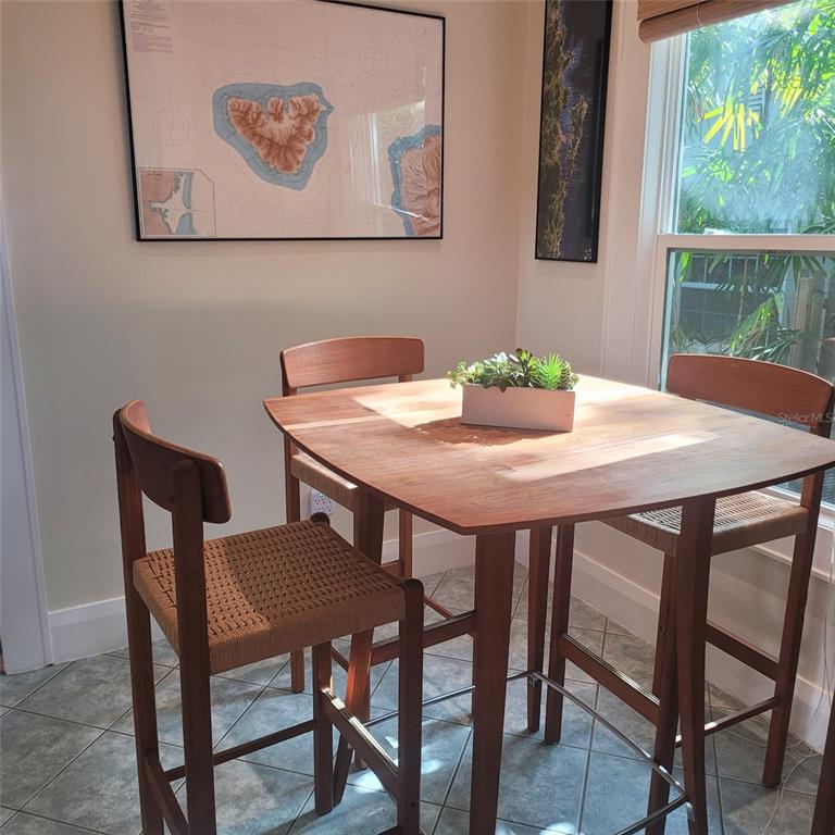A high-top wooden dining set with woven seats sits in a room with tiled floors — 2916 W BAY COURT AVENUE, TAMPA, FL