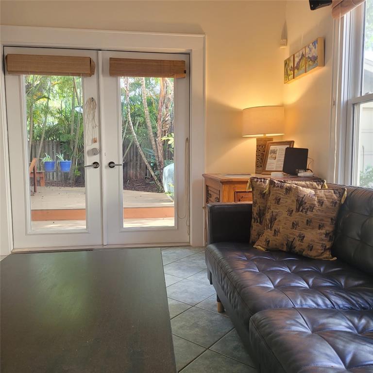 A living room features a dark leather sofa, tile flooring, and glass doors to a deck — 2916 W BAY COURT AVENUE, TAMPA, FL