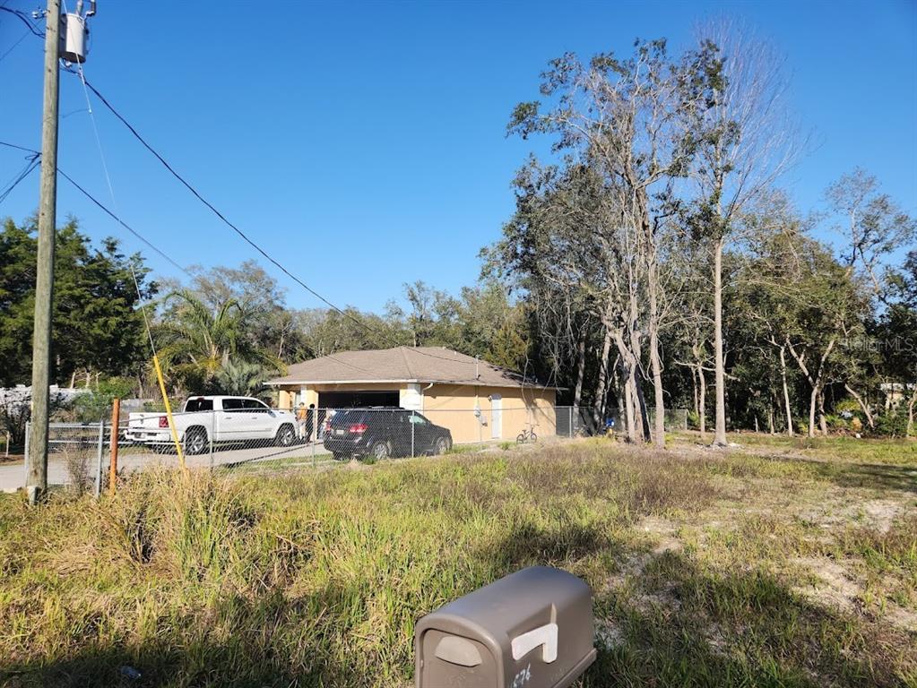 A tan house with a garage sits behind a grassy lot with a mailbox — LOT 19 NW 119 TH COURT, OCALA, FL