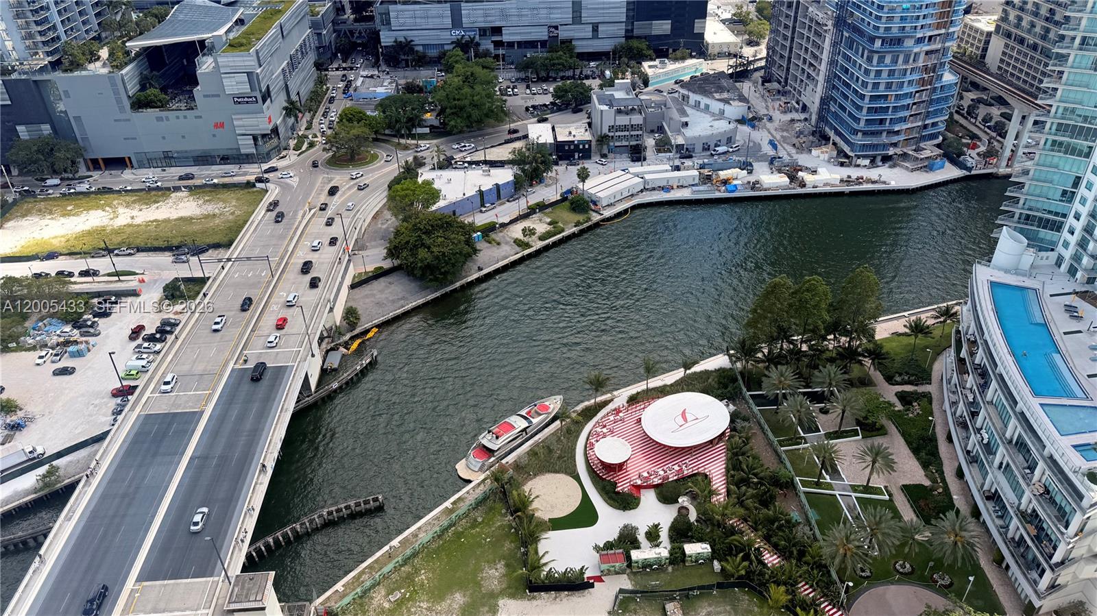 An aerial view shows a bridge over a canal, a yacht, and a waterfront park — 350 S Miami Ave # 3608, Miami FL 33130, MIAMI, FL
