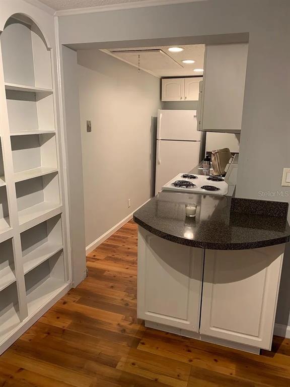 A kitchen with white cabinets, a dark countertop, and a white refrigerator — 4301 E MICHIGAN STREET UNIT 4301, ORLANDO, FL