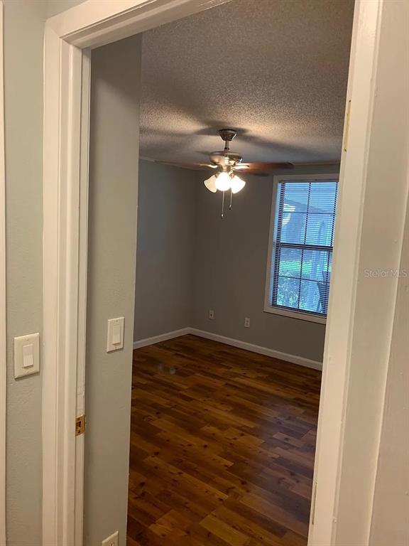 A view through a doorway into a bedroom with wood-look flooring and a ceiling fan — 4301 E MICHIGAN STREET UNIT 4301, ORLANDO, FL