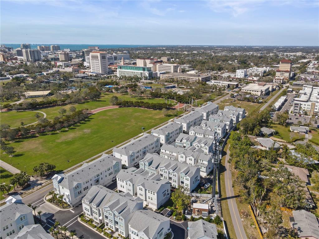 An aerial view shows a modern residential townhouse complex adjacent to a large public park — 2505 BOONE COURT, SARASOTA, FL