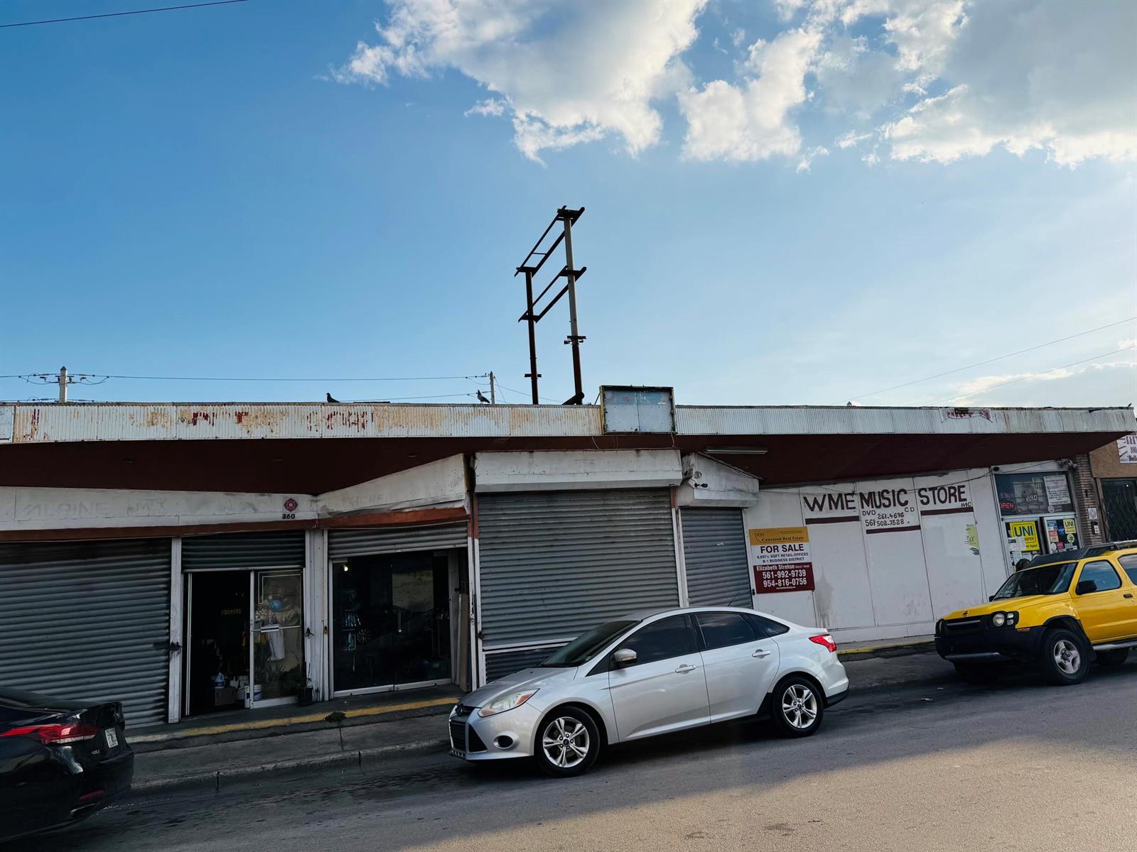 A street-level view of a commercial building with a music store and a for-sale sign — 364 W Avenue A, Belle Glade FL 33430, BELLE GLADE, FL
