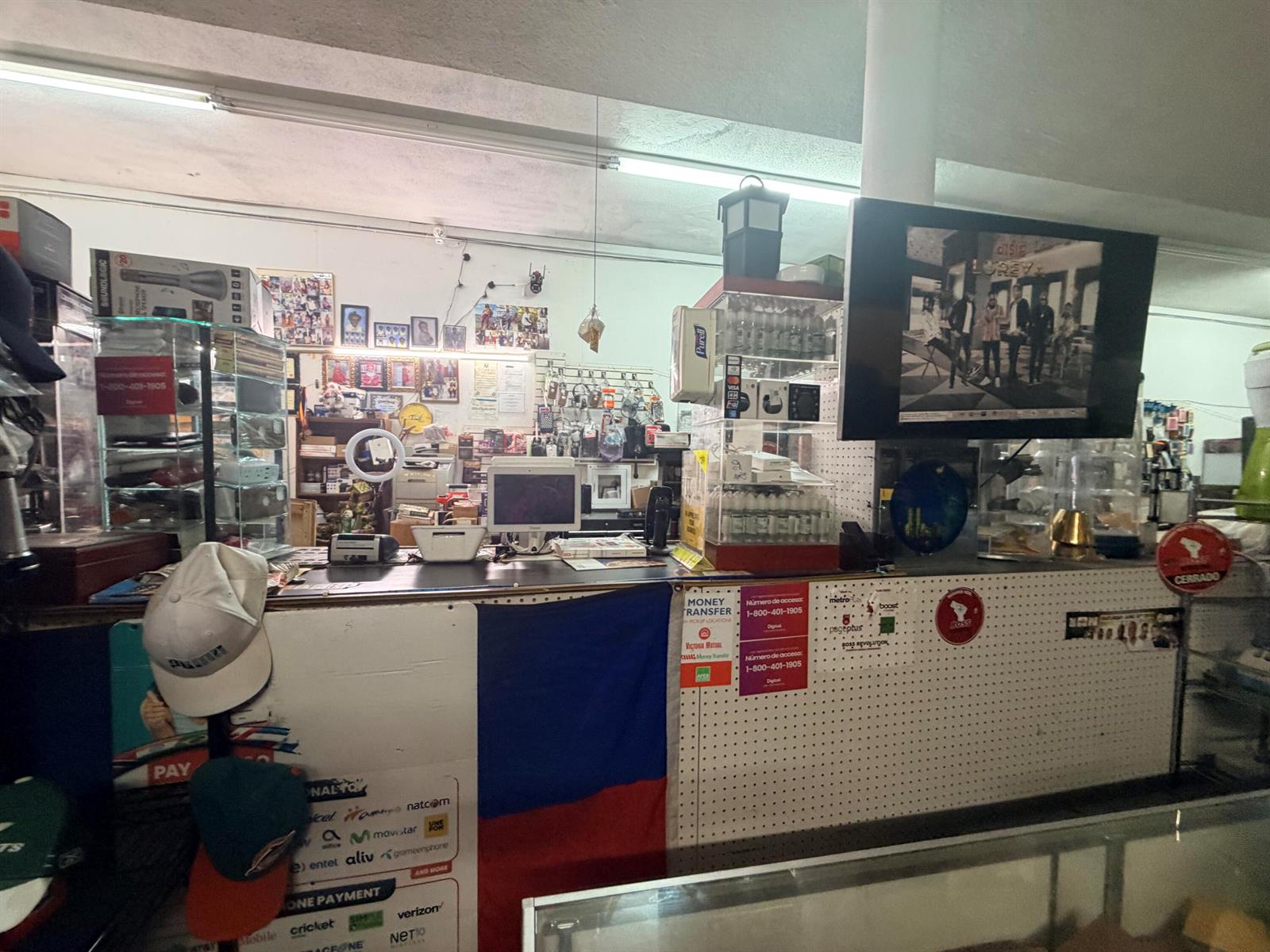 The interior of a retail store features a service counter with electronic equipment and signage — 364 W Avenue A, Belle Glade FL 33430, BELLE GLADE, FL