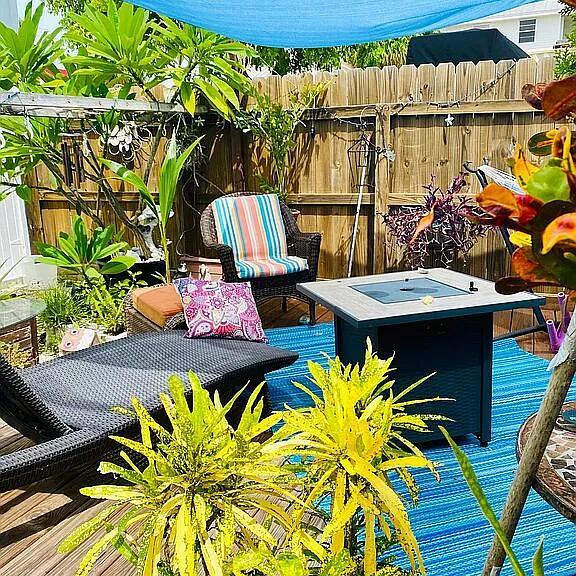 A backyard patio features a wicker lounge chair, a striped armchair, and a square fire pit — 1361 Overseas Highway # G5, Marathon FL 33050, MARATHON, FL