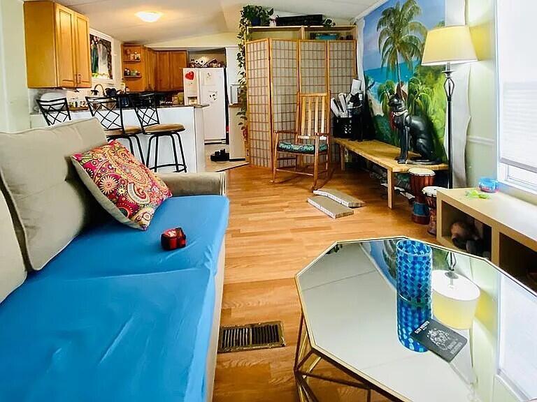 A living room with a blue sofa, a mirrored coffee table, and a kitchen area — 1361 Overseas Highway # G5, Marathon FL 33050, MARATHON, FL