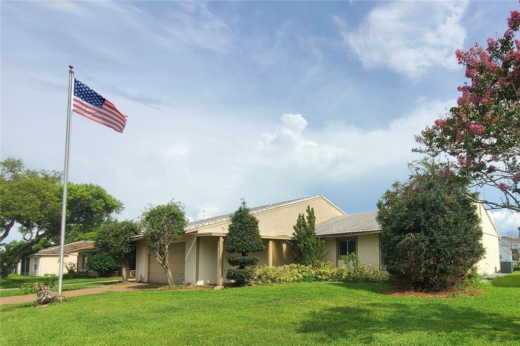 A single-story house with a beige exterior, a tiled roof, and an American flag pole — 5540 MINUTE MAN COURT, ORLANDO, FL