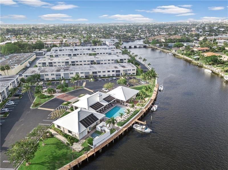 An aerial view shows a waterfront residential complex with a swimming pool and boat docks — 110 Cypress Club Dr # 108, Pompano Beach FL 33060, POMPANO BEACH, FL