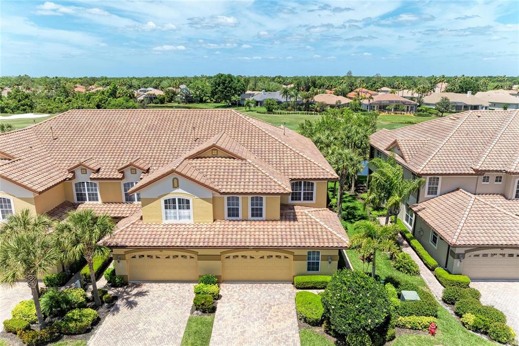 An aerial view of two attached suburban houses with tiled roofs and paved driveways — 8432 MIRAMAR WAY, LAKEWOOD RANCH, FL