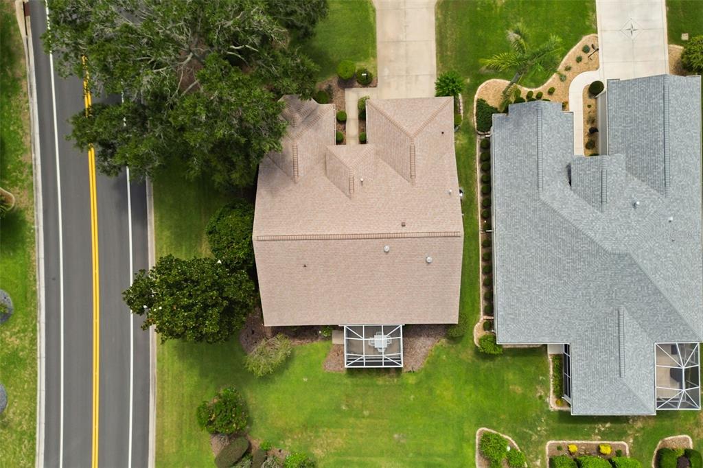 An aerial view shows two suburban houses with shingled roofs, driveways, and back patios — 1312 BAEZ WAY, THE VILLAGES, FL