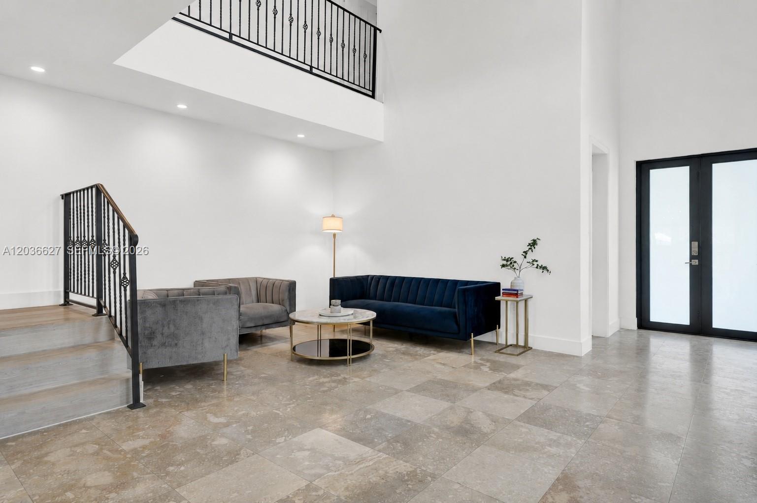 A modern living room features a blue velvet sofa, grey armchairs, and a staircase — 3022 SW 17th St # 3022, Miami FL 33145, MIAMI, FL