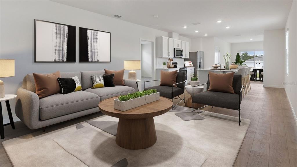 This rendering shows an open-concept living room and kitchen with modern furniture and wood flooring — 5144 BLANKET FLOWER STREET, APOPKA, FL