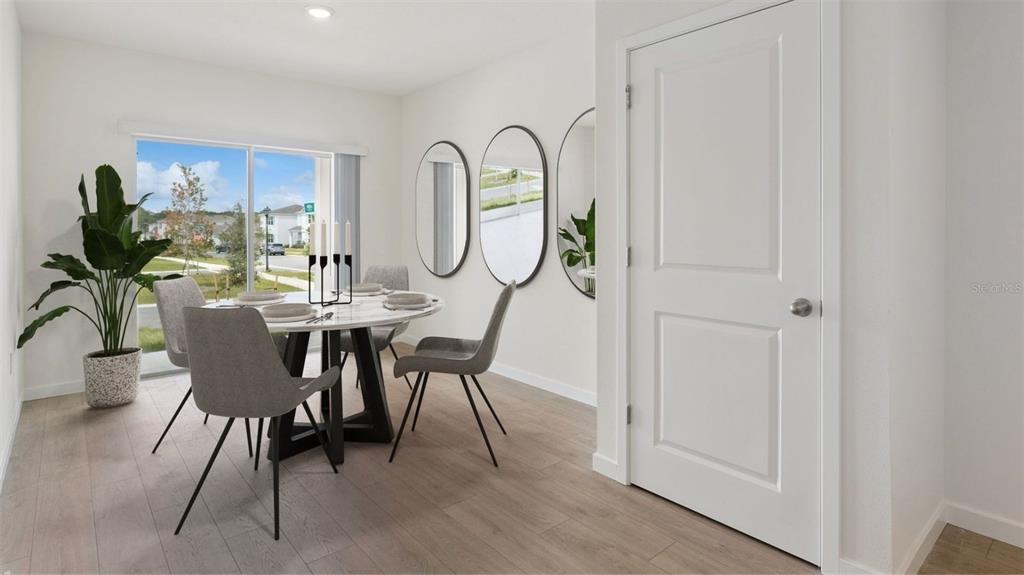 A dining room features a round table, four gray chairs, and three oval wall mirrors — 5144 BLANKET FLOWER STREET, APOPKA, FL