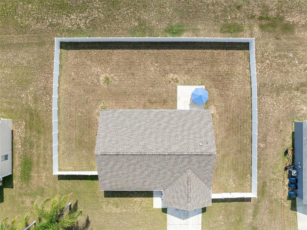 An aerial view shows a house with a fenced backyard and a blue patio umbrella — 122 CHURCH STREET S, LAKE HAMILTON, FL