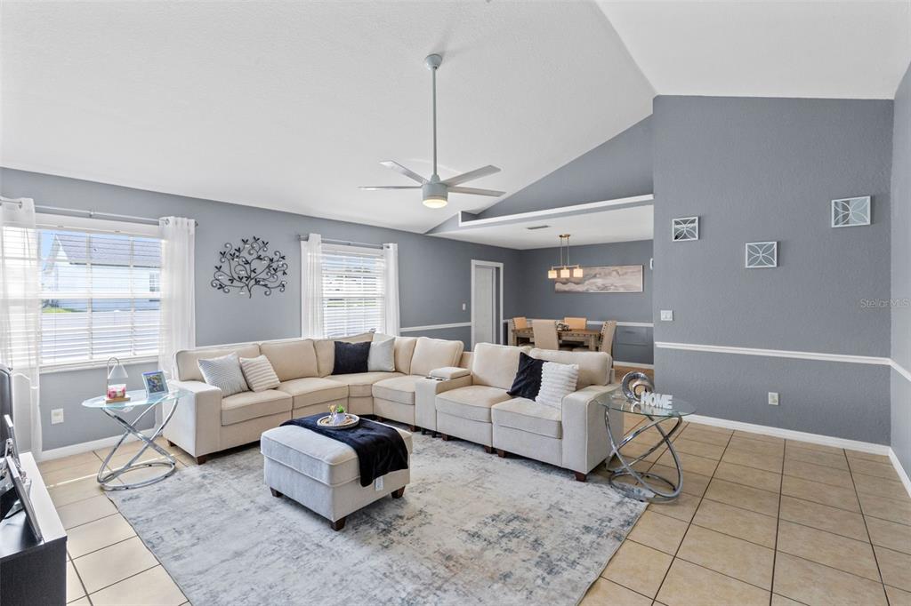 A living room with a sectional sofa, area rug, and vaulted ceiling with a fan — 122 CHURCH STREET S, LAKE HAMILTON, FL